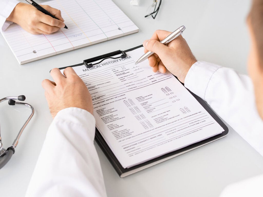 Doctor filling out medical paperwork