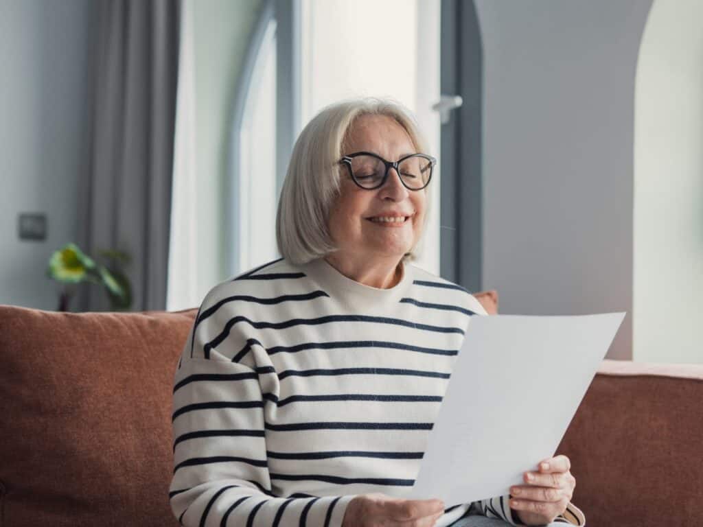 Smiling senior woman reading a letter while sitting